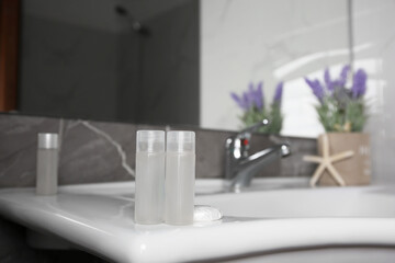 Bottles of shower gel on sink in bathroom. Space for text