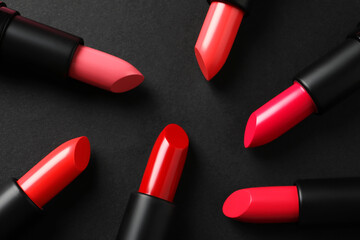 Fototapeta premium Beautiful lipsticks on black background, flat lay