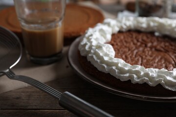 Fototapeta na wymiar Delicious homemade sponge cake with cream on wooden table, closeup