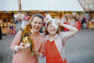 Portrait of smiling mother and teenage daughter at fair in city