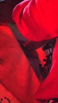 Vertical video of Black man standing moving around plucking kora in front of microphone