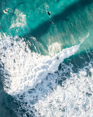 Spectacular aerial view of a surfer taking on waves in a blue ocean