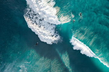 Spectacular aerial view of a surfer taking on waves in a blue ocean