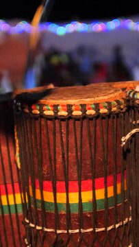 Vertical video of Bunch of congas drums played with wooden stick by standing black man