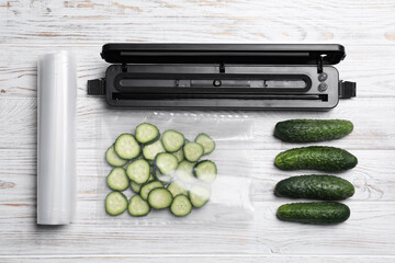 Sealer for vacuum packing, plastic bags and cucumbers on white wooden table, flat lay