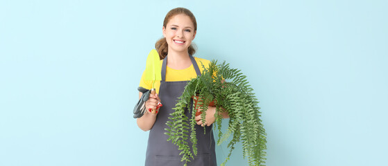Portrait of female gardener on light blue background