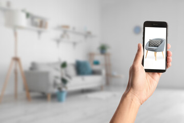 Woman with mobile phone buying online new armchair in furniture store at home