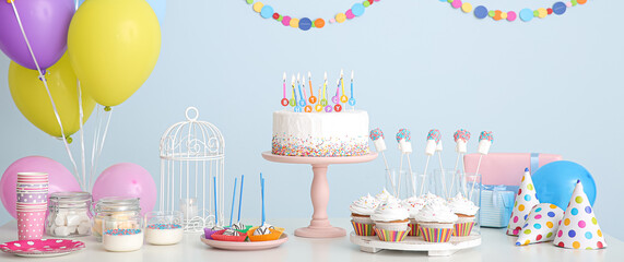 Tasty candy bar for Birthday party on table against light blue background