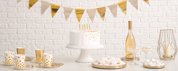 Tasty candy bar for Birthday on table near white brick wall