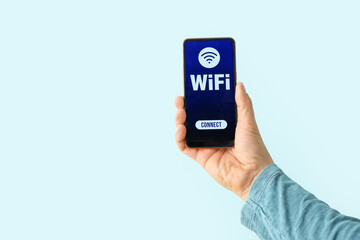 Man holding mobile phone with WiFi symbol and connection button on color background, closeup