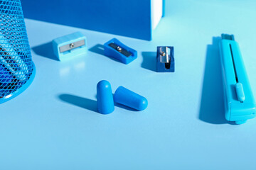 Foam earplugs and stationery on blue background