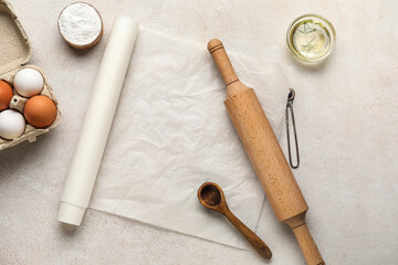 Baking paper with kitchen supplies and ingredients on light background