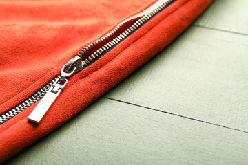 Clothes with metal zipper on green wooden background © Pixel-Shot
