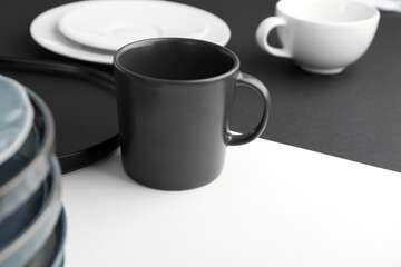 Obraz na płótnie Canvas Mug on black and white table, closeup