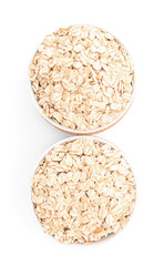 Bowls of raw oatmeal isolated on white background