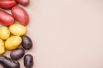 Different types of potatoes on color background