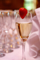 Tall glass with sparkling wine champagne and strawberries, wedding