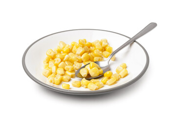 Plate with canned corn and spoon isolated on white background