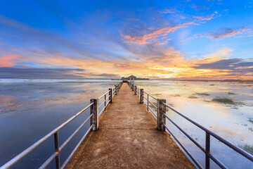 Empty concrete bridge under sunset golden sky with clouds above lake, tourist attraction Nong Han lake at Sakon Nakhon province in thailand