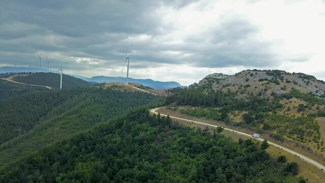 drone view of forest road and windmills