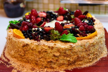 napoleon cake decorated with berries and fruits, drops of white chocolate.
