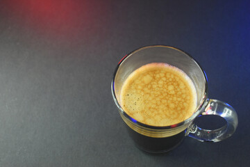hot black coffee on black table with neon lights