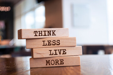 Wooden blocks with words 'Think less live more'.