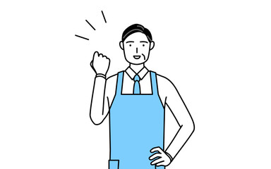 ガッツポーズをするエプロンを着たシニア男性