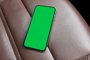 Smartphone in a car use for navigate or GPS. Mobile phone with isolated green screen with chroma...