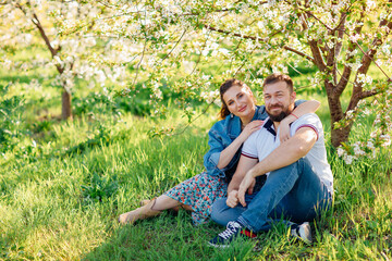 Fototapeta premium a man and a woman on a lawn in a blooming spring garden. 