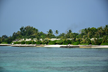 Maldives island landscape. Water, sand and greenery. Lush, tropical, vegetation, palm trees and...