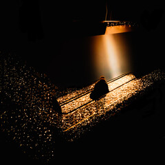 A person is taking an escalator to an upper floor in a shopping centre. Everything is lit up in...