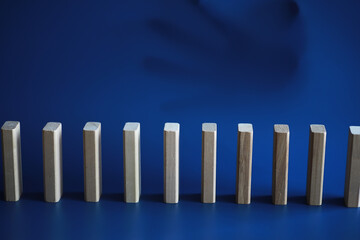 Closeup thick domino wood block in a row stop the falling, be stable in crisis, business solution concept