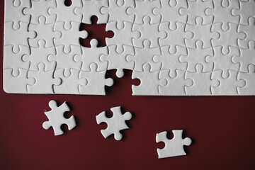 Clean puzzle elements on the red background. Empty puzzle piece on the table. Teamwork concept.