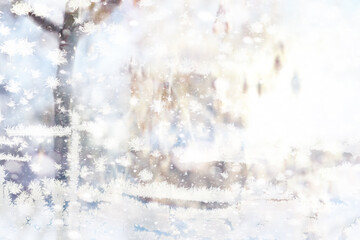 Fototapeta premium Winter landscape through a frozen window. Blurred snow background. Trees and plants covered with snow.