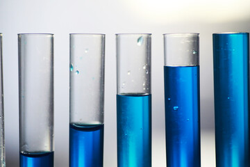 Test tube with blue liquid on the laboratory table. Examination of liquid under a microscope.