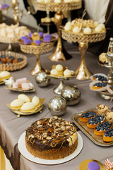 Table with cakes, sweets, candy, buffet. Dessert table for a party goodies for the wedding banquet area. Close up candy bar. Decorated delicious.