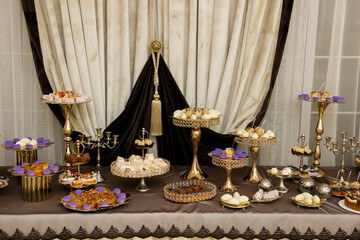 Table with cakes, sweets, candy, buffet. Dessert table for a party goodies for the wedding banquet area. Close up candy bar. Decorated delicious.