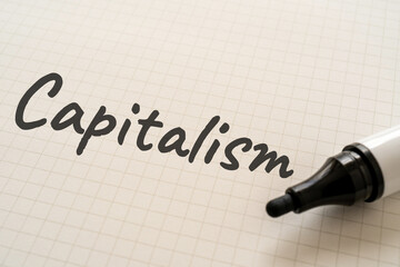 Capitalismと書かれた紙とマーカー