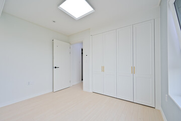 The built-in wardrobe has the same texture as the wallpaper color to give a neat interior unity