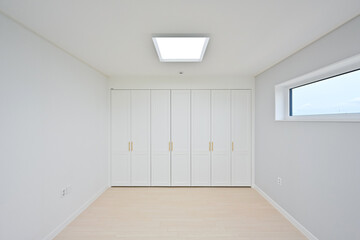 A small room with a sense of interior unity with built-in cabinets on one wall
