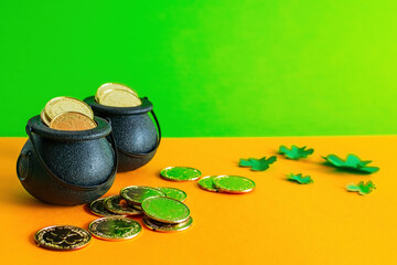 Pots of gold coins on orange and green background.