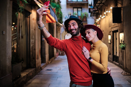 Couple embracing and taking a selfie in the street