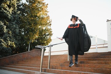 Portrait of a confident and joyful young graduate with a diploma. Man is ready for the next step in...