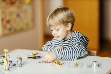 A happy child is playing with educational game at kindergarten and learning music instruments.