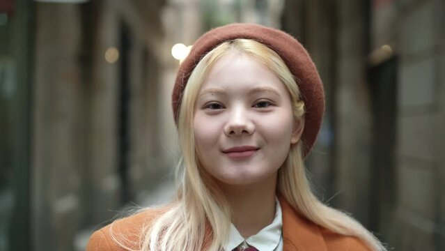 Asian blonde woman looking at camera in the street