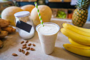 Healthy protein shake on table with fruits and vegetables ingredients around.