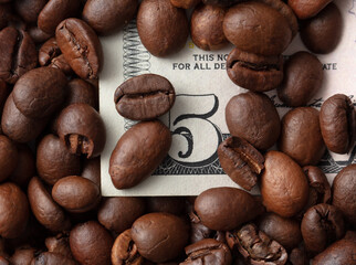 Banknote five dollars in black coffee beans.