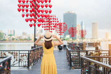 Woman Traveler with yellow dress visiting in Da Nang. Tourist sightseeing at love lock bridge. Landmark and popular. Vietnam and Southeast Asia travel concept