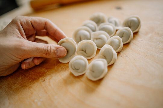 Woman arranging dumplings on cutting board